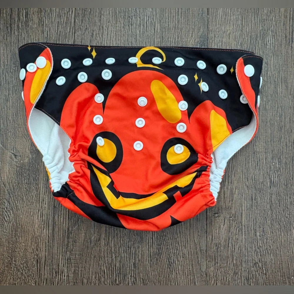 Like new pumpkin jack o lantern Halloween cloth snap diaper or cover up.